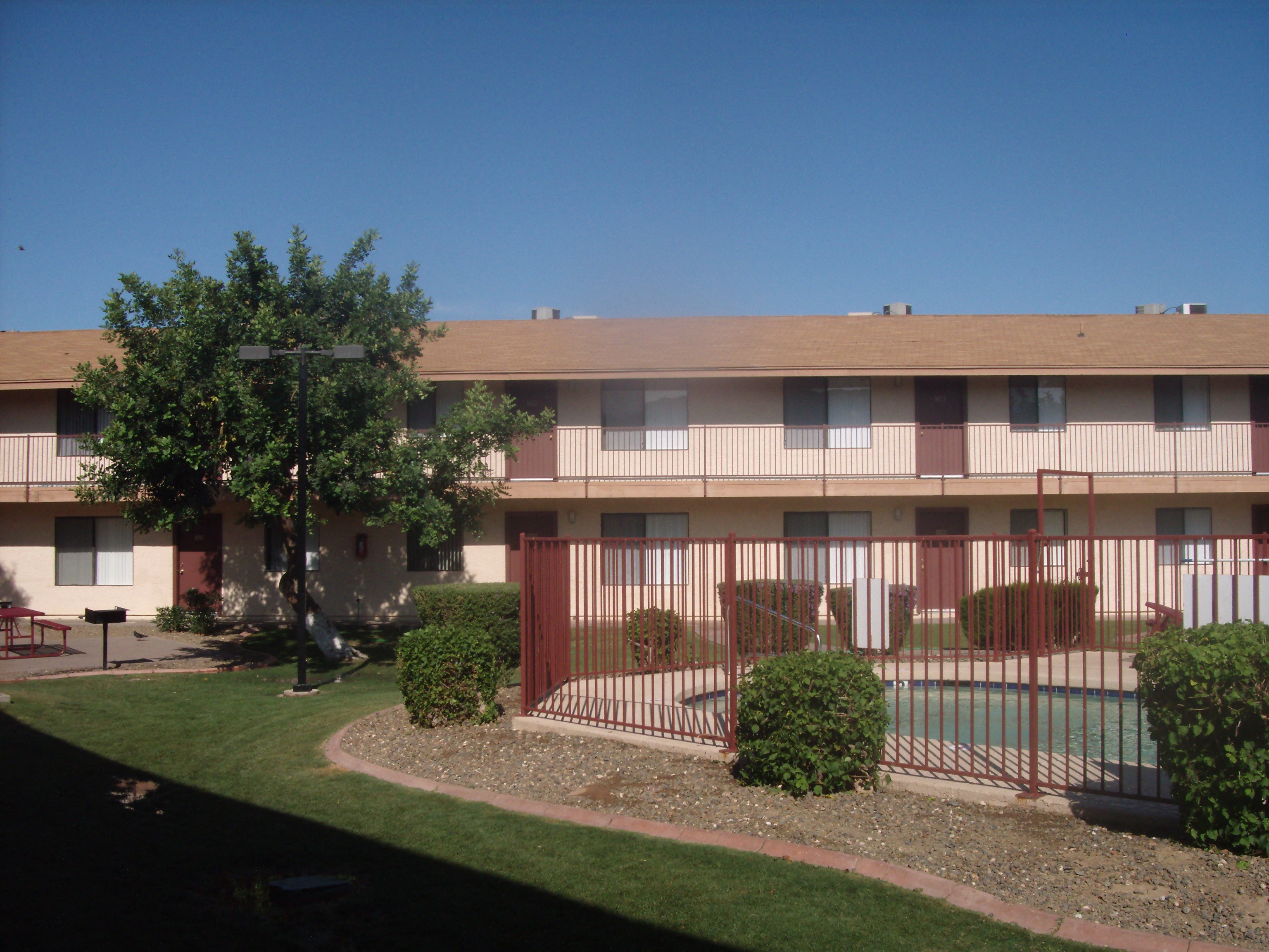 an apartment building with a yard and a fence